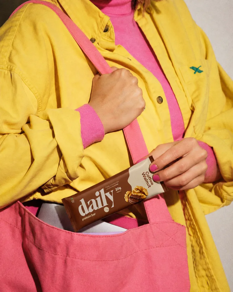 A daily bar being pulled from a pink tote bag